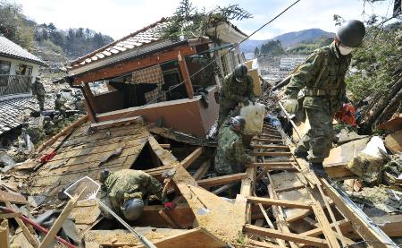 　東日本大震災で倒壊した家屋の内部を捜索する陸上自衛隊員ら＝２０１１年３月、宮城県女川町