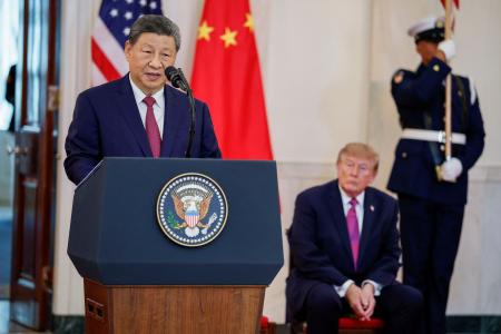 　ワシントンのホワイトハウスで開かれた式典であいさつする中国の習近平国家主席。奥はトランプ米大統領＝２４日（ロイター＝共同）