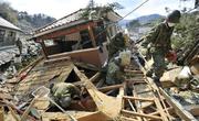 　東日本大震災で倒壊した家屋の内部を捜索する陸上自衛隊員ら＝２０１１年３月、宮城県女川町