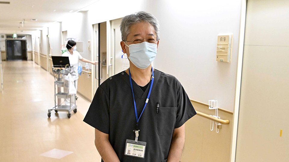 コロナ病棟に立つ加藤達雄医師。廊下は「グリーン」なので、個人防護具はマスクにとどまる＝１３日、岐阜市長良、長良医療センター