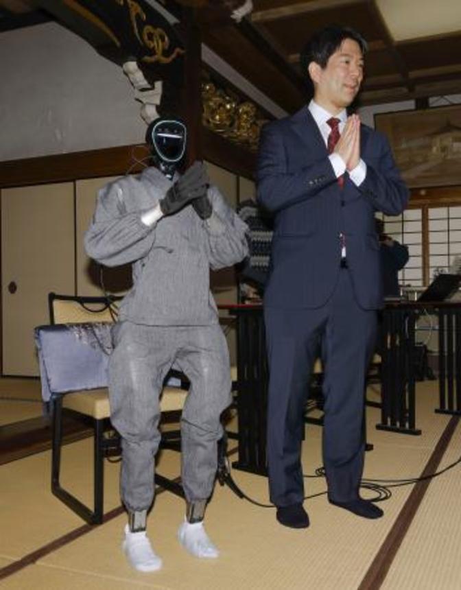 　仏教経典を学習した生成ＡＩを搭載した人型ロボット「ブッダロイド」と、開発した京都大の熊谷誠慈教授＝２４日午後、京都市東山区