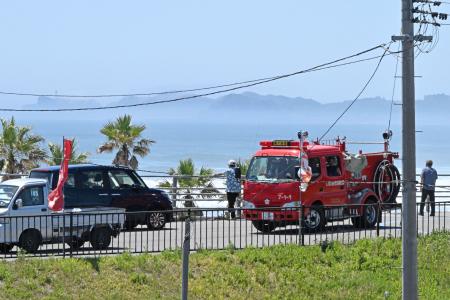 　津波警報が発令され、高台から海を見る人＝３０日午前、福島県いわき市の四倉海岸