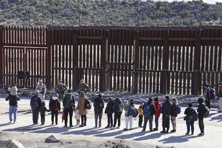 　米国境警備隊員らの前で並ぶ中国からの不法移民ら＝２０２４年１月、カリフォルニア州ハクンバホットスプリングス（共同）