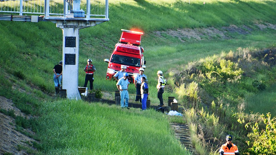 トラックが転落した水路を調べる署員ら＝８日午後、羽島市桑原町西小薮