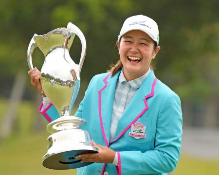 　通算１４アンダーで優勝しトロフィーを手に笑顔の神谷そら＝福岡雷山ＧＣ