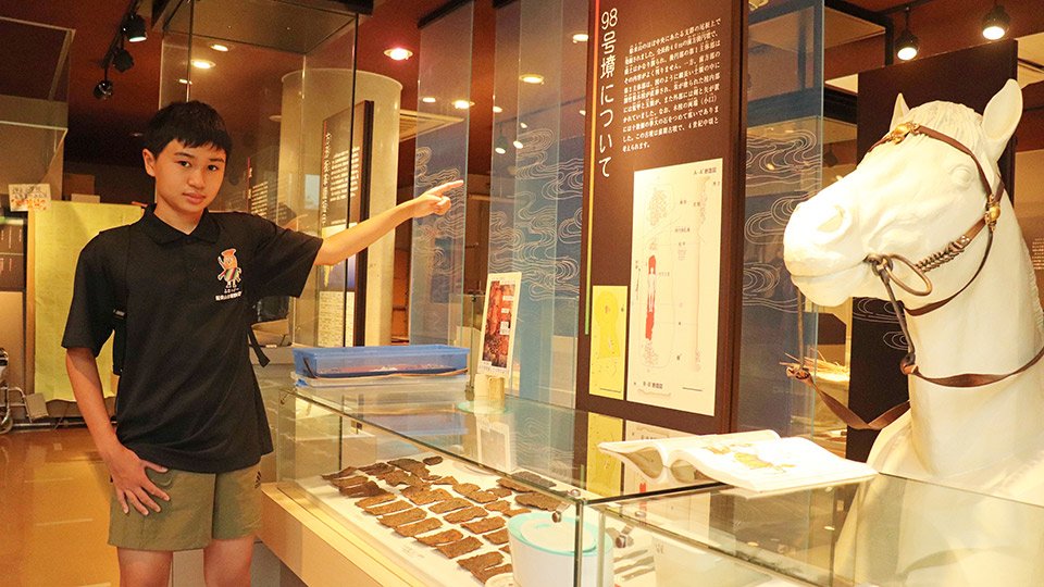 古墳から出土した馬具を説明する菊地政吾さん＝本巣市上保、古墳と柿の館