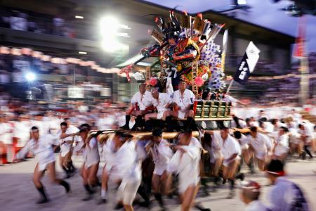 　福岡の夏を彩る伝統の祭り「博多祇園山笠」の「追い山笠」で、櫛田神社の境内を駆け抜ける「千代流」の舁き山笠＝１５日早朝、福岡市