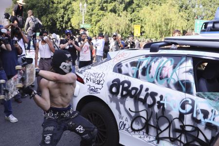 　米ロサンゼルスで車両を破壊する暴徒＝６月（共同）