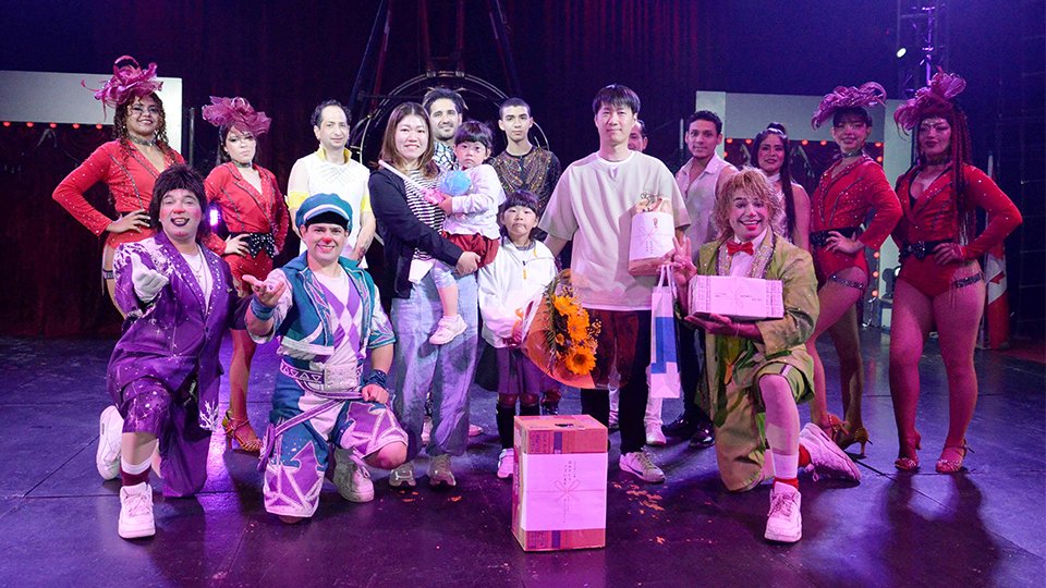２万人目の来場者となり団員から祝福される馬淵慎司さん一家＝大垣市外野、イオンモール大垣北側駐車場特設会場
