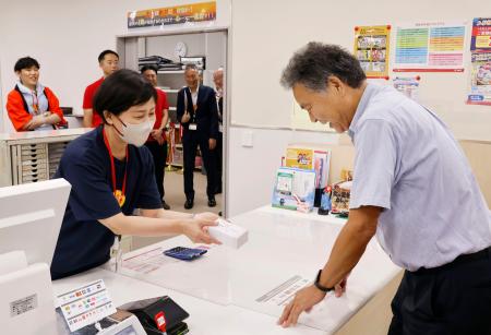 　新庁舎で開局した穴水郵便局を訪れた利用客（右）＝１２日午前、石川県穴水町