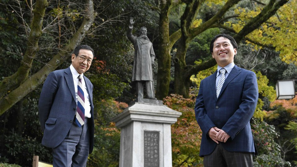 板垣退助像を前にする中元崇智中京大教授（右）と矢島薫岐阜新聞社社長＝岐阜市大宮町、岐阜公園