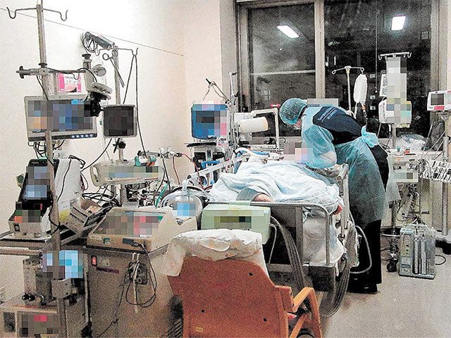 医療機器につながれた新型コロナウイルス重症患者を診る医師＝５月、岐阜市柳戸、岐阜大病院（同病院提供）