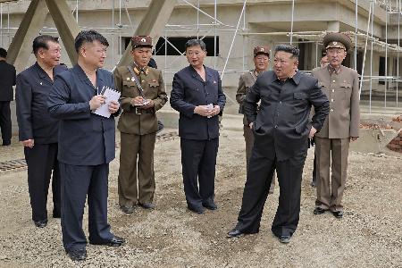 　建設現場を視察する北朝鮮の金正恩朝鮮労働党総書記（手前右）に同行するキム・ボクナム少将（右端）と素性不明の党幹部（左から２人目）＝６月、平壌の江東地区（朝鮮中央通信＝共同）