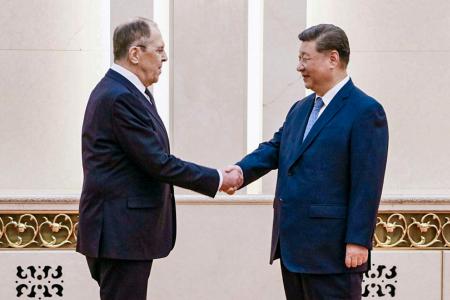 　ロシアのラブロフ外相と（左）と握手する中国の習近平国家主席＝１５日、北京（タス＝共同）