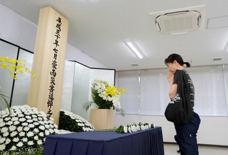 　西日本豪雨から７年となり、岡山県倉敷市真備町地区で献花する女性＝６日午前