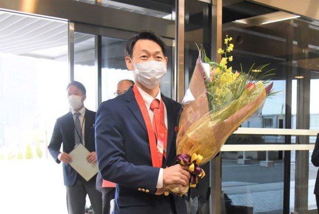 職員から花束を受け取り、拍手で迎えられる永井秀昭選手＝岐阜県庁