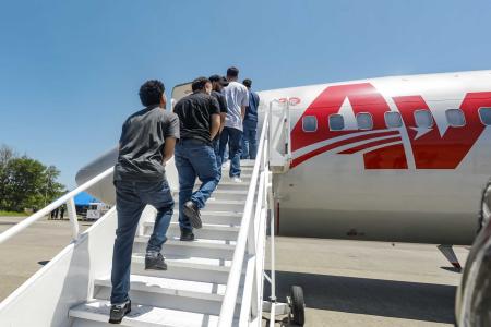 　飛行機に乗り出国するベネズエラ人＝１８日、エルサルバドル南部（同国大統領府提供・ゲッティ＝共同）